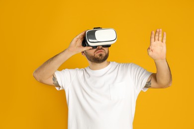 Photo of Man using virtual reality headset on yellow background