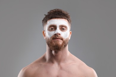 Photo of Handsome man with facial mask on his face against grey background