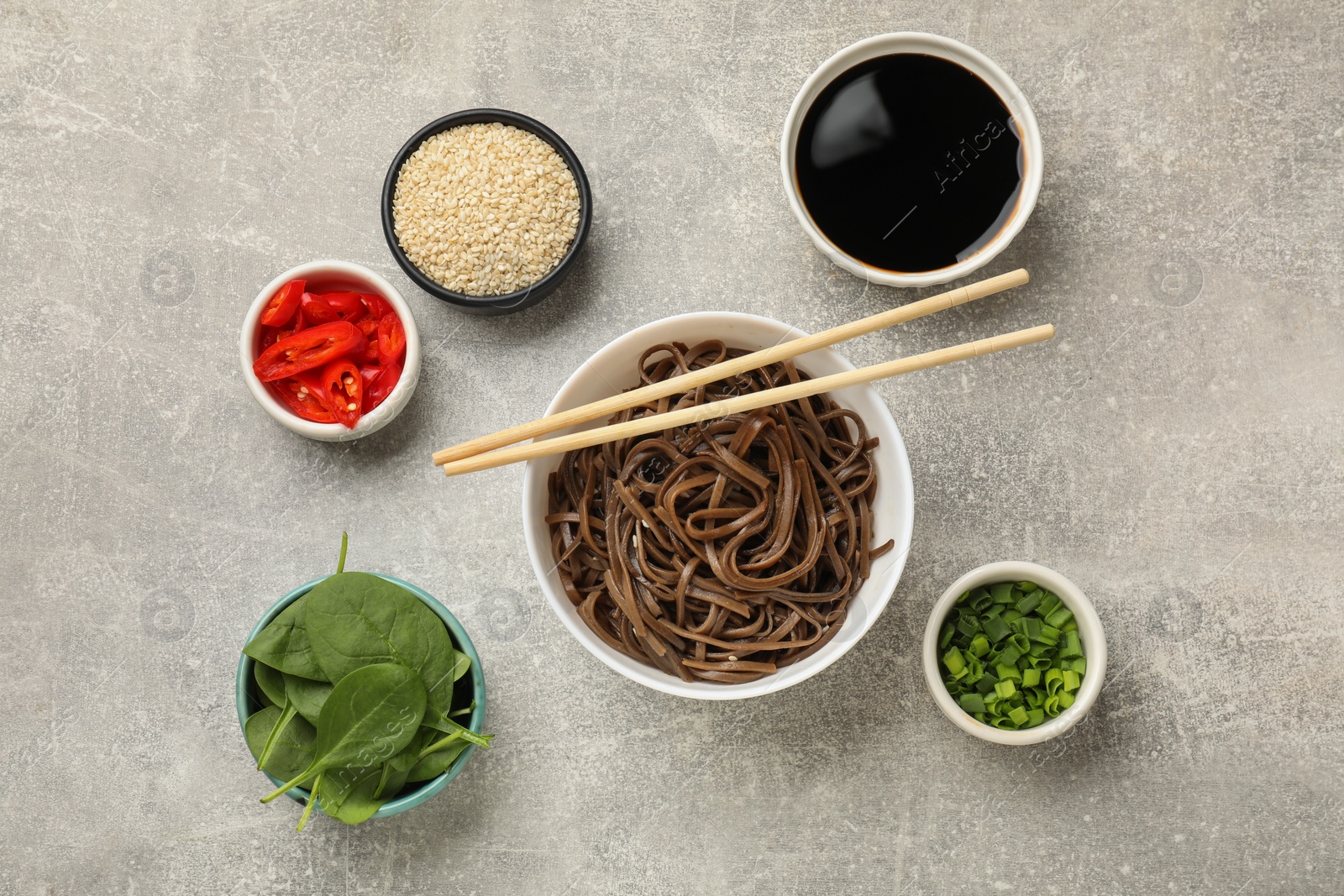 Photo of Tasty buckwheat noodles (soba) served on light grey table, flat lay