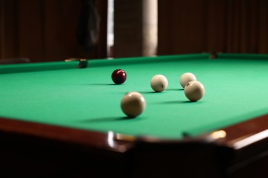 Many billiard balls on green table indoors