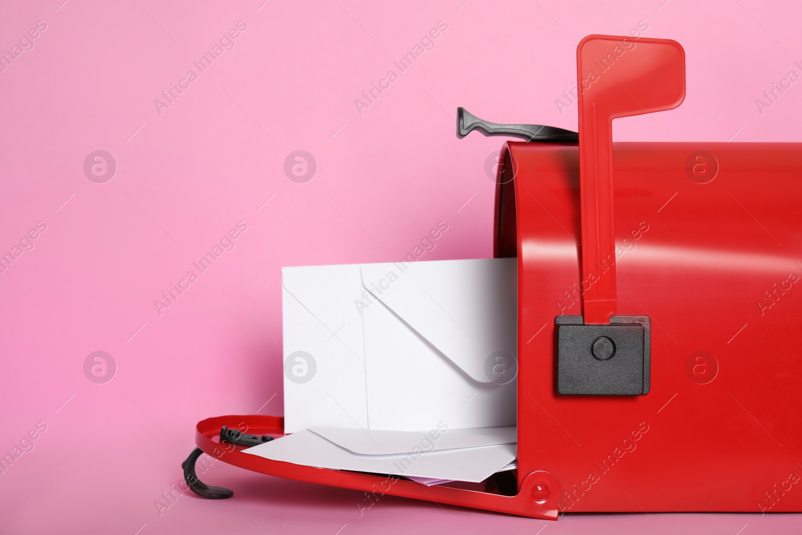 Photo of Open red letter box with envelopes on pink background, closeup