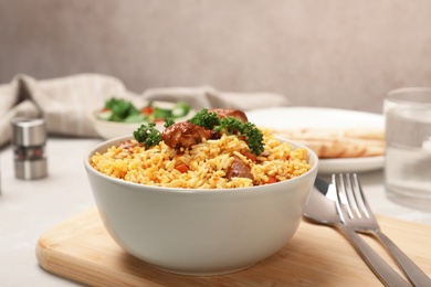 Bowl of tasty rice pilaf with meat on table