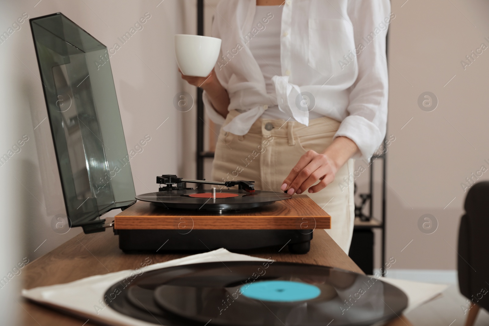 Photo of Woman using turntable at home, closeup view