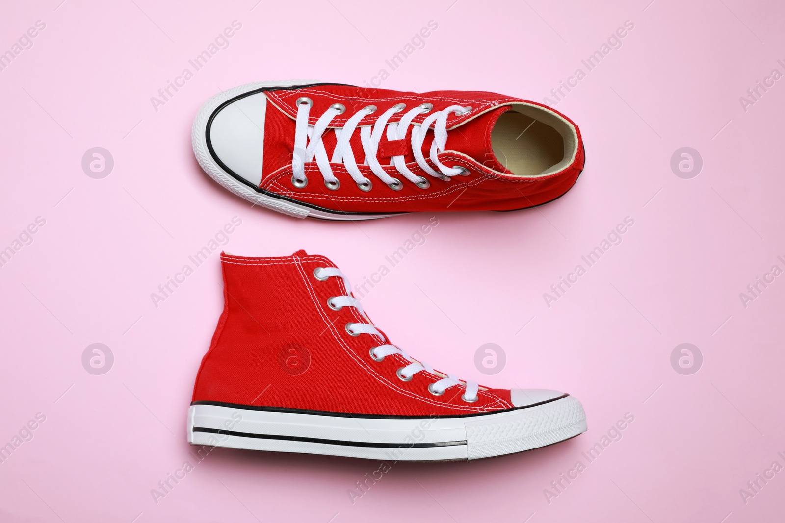 Photo of Pair of new stylish red sneakers on pink background, flat lay