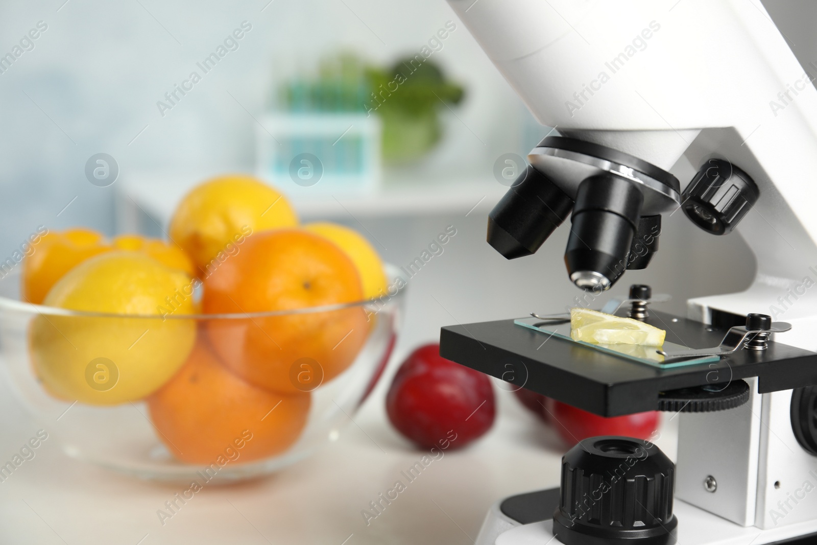 Photo of Slide with slice of lemon on microscope in laboratory, space for text. Poison detection