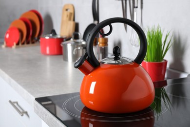Photo of Red kettle on electric stove in kitchen, space for text