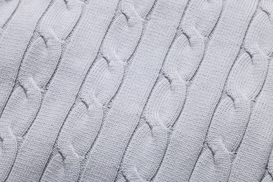 Photo of Texture of light grey knitted fabric as background, top view