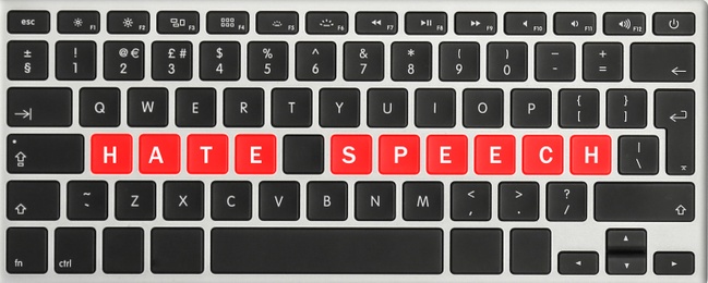 Image of Red buttons with text Hate Speech on computer keyboard, top view