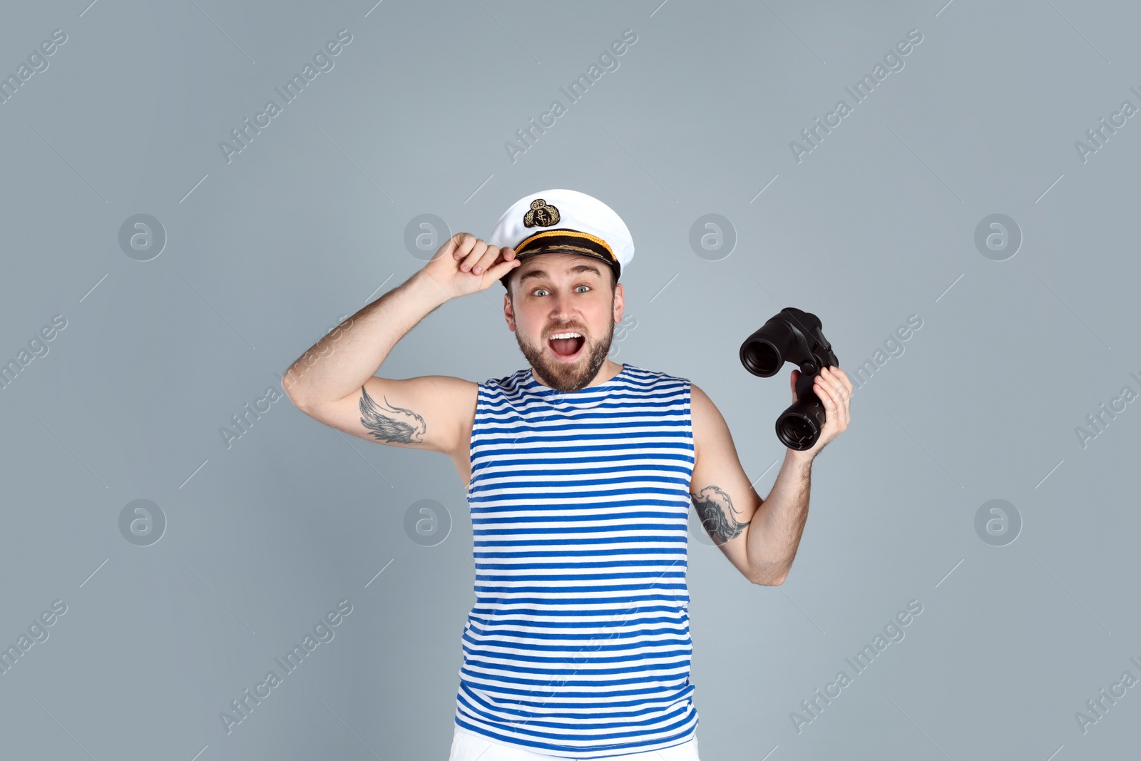 Photo of Emotional sailor with binoculars on light grey background