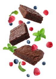 Image of Slices of delicious chocolate brownie with fresh berries and mint flying on white background