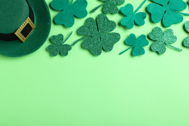 Flat lay composition with leprechaun hat on light green background, space for text. St. Patrick's Day celebration