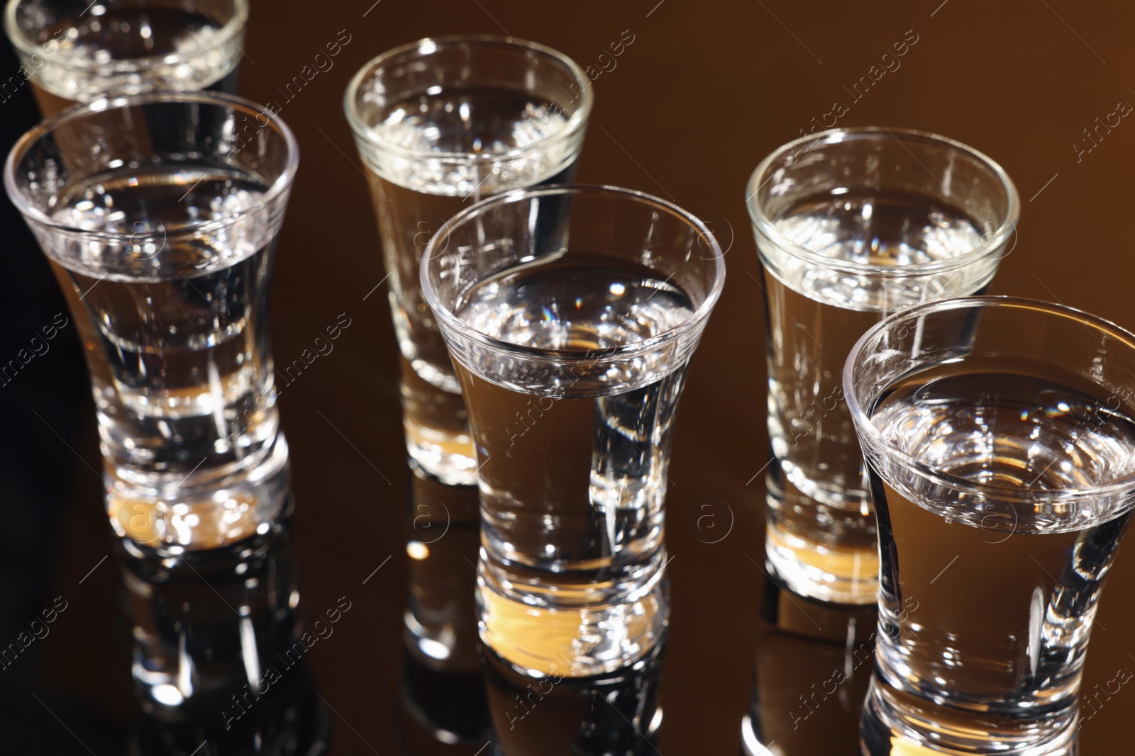 Photo of Shot glasses with vodka on dark table