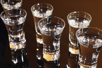 Shot glasses with vodka on dark table