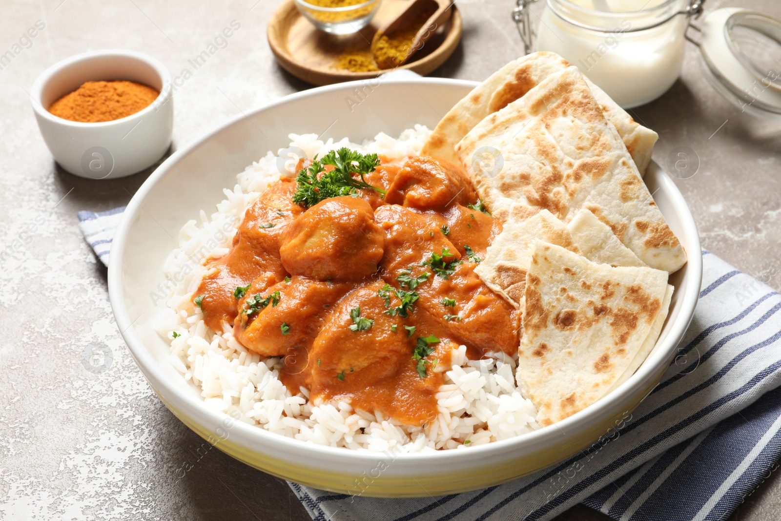 Photo of Delicious butter chicken with rice in plate on table
