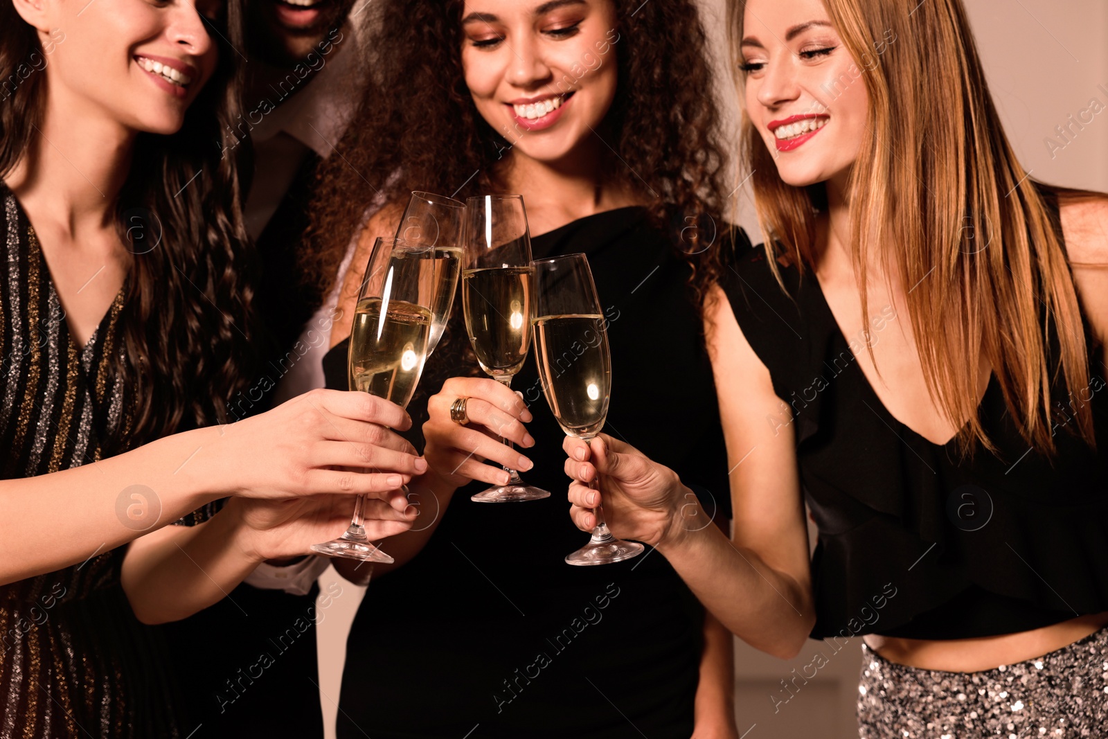 Photo of Happy friends with glasses of sparkling wine celebrating New Year indoors, closeup