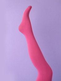 Photo of Leg mannequin in pink tights on violet background