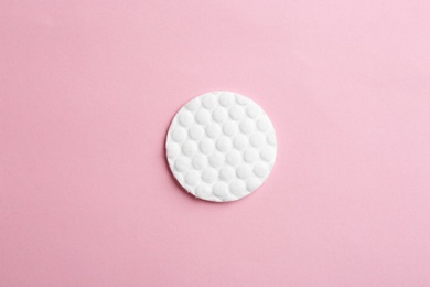 Cotton pad on color background, top view