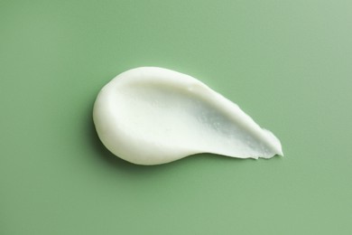 Photo of Sample of face scrub on green background, top view