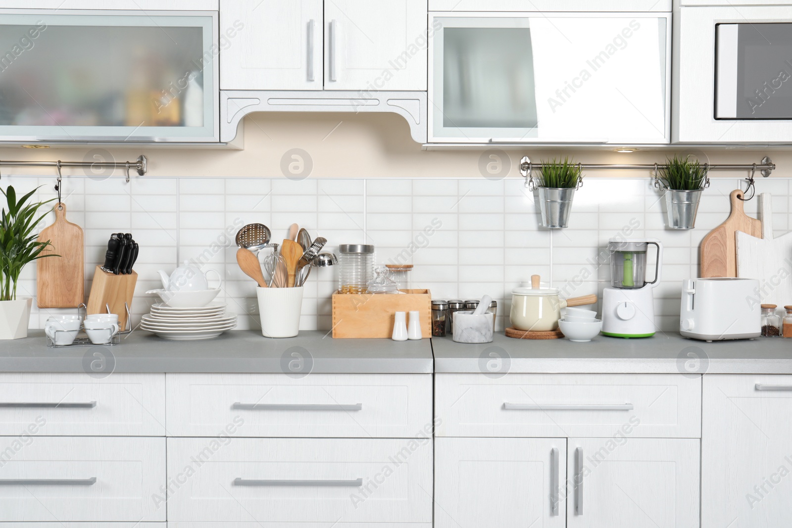 Photo of Different appliances, clean dishes and utensils on kitchen counter