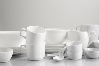 Photo of Set of many clean dishware on light table