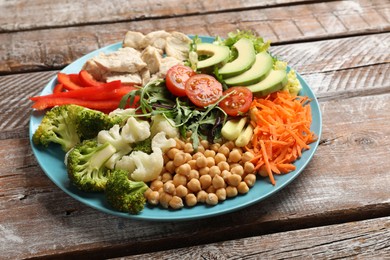 Balanced diet and healthy foods. Plate with different delicious products on wooden table