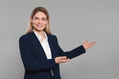Photo of Happy real estate agent on grey background. Space for text
