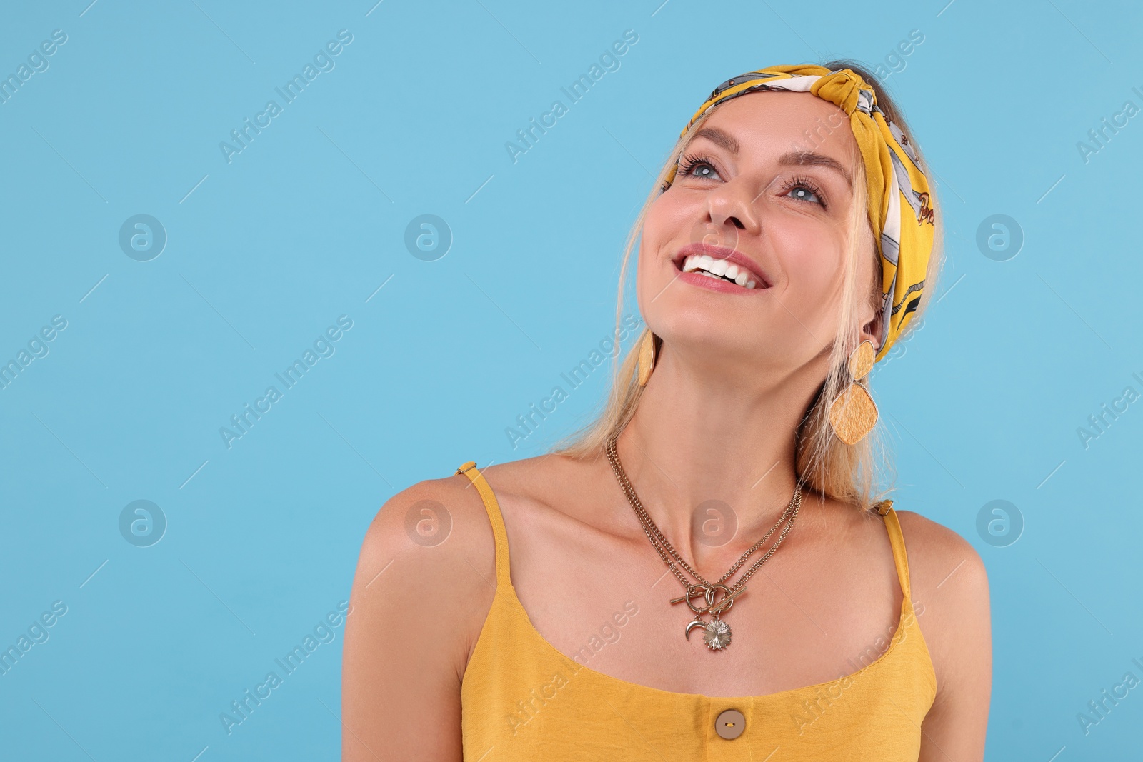 Photo of Portrait of happy hippie woman on light blue background. Space for text