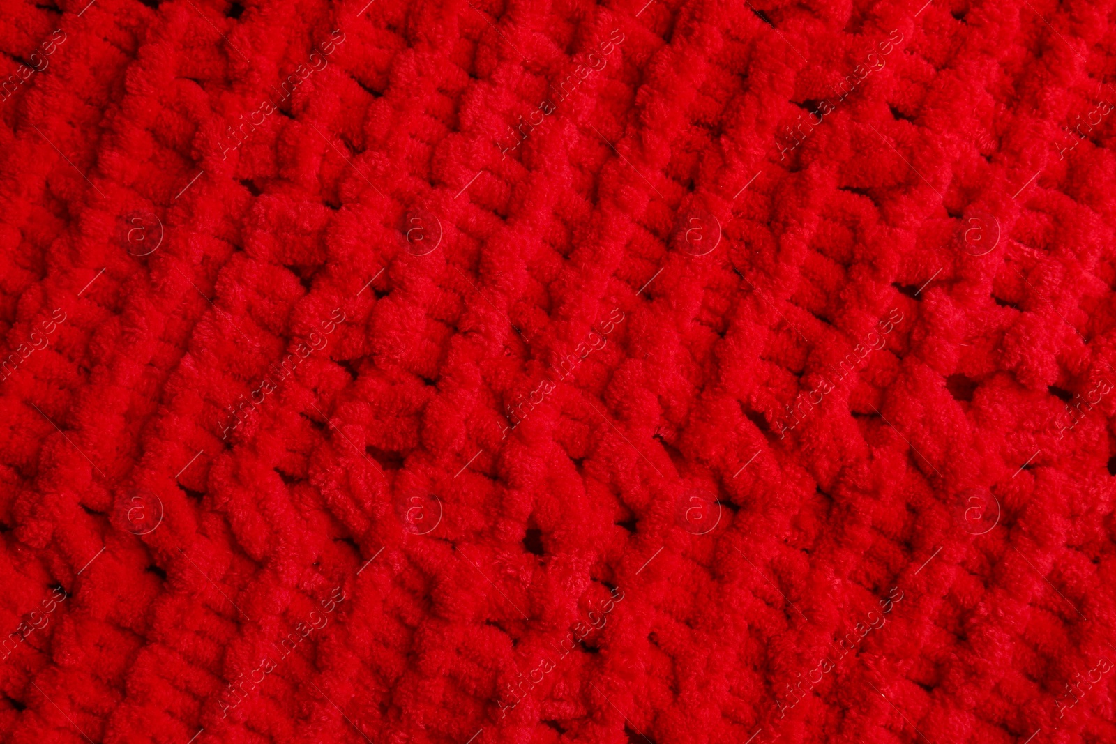 Photo of Soft red knitted fabric as background, top view