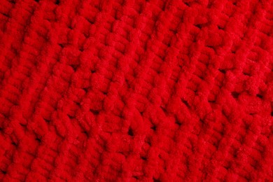 Photo of Soft red knitted fabric as background, top view