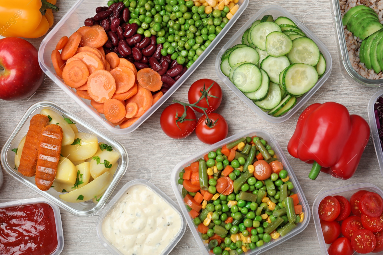 Photo of Set of containers and fresh food on white wooden table, flat lay