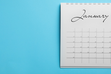 Photo of January calendar on light blue background, top view. Space for text