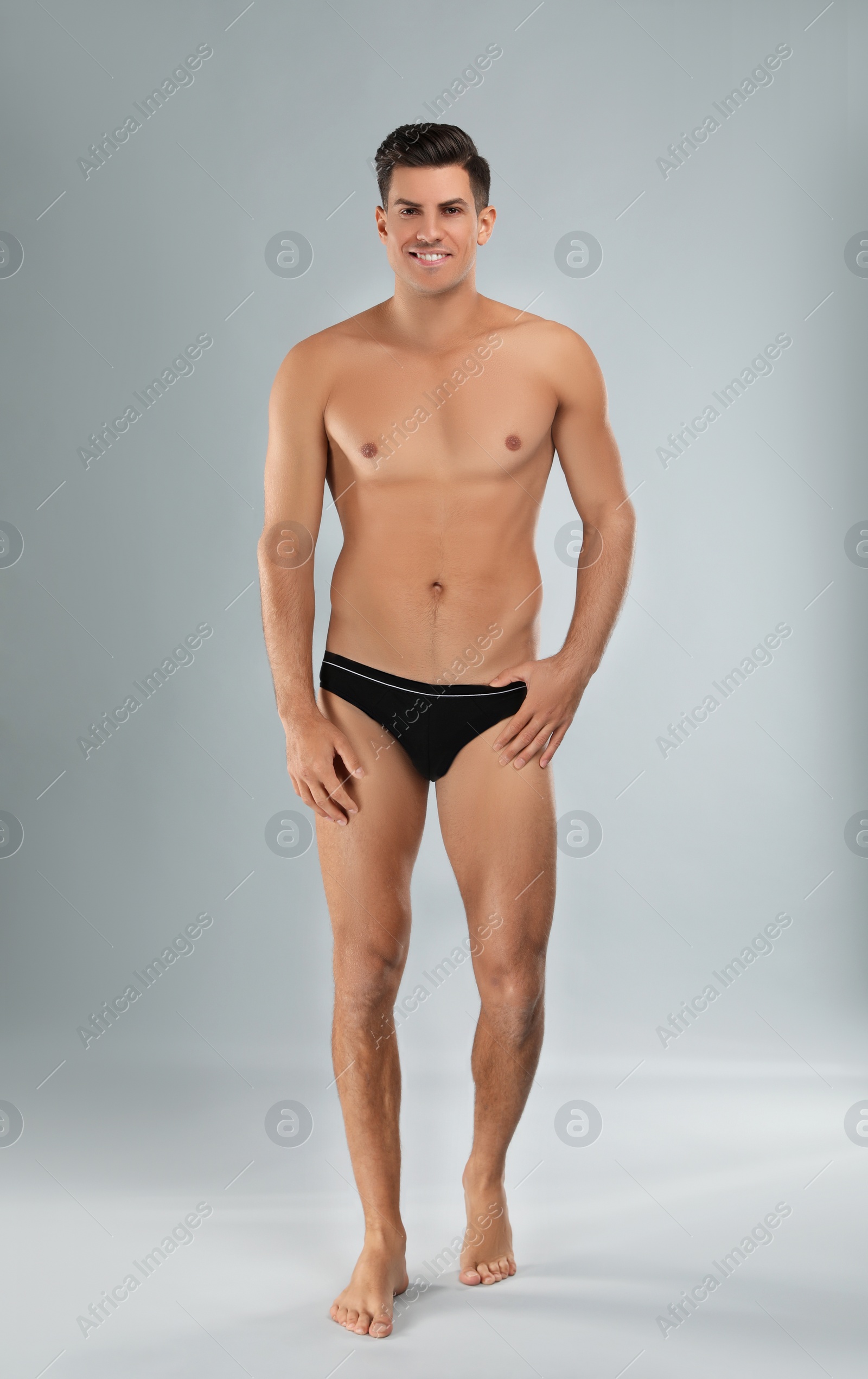 Photo of Handsome man in black underwear on light grey background