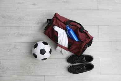 Sports bag with training stuff and equipment on white floor, flat lay