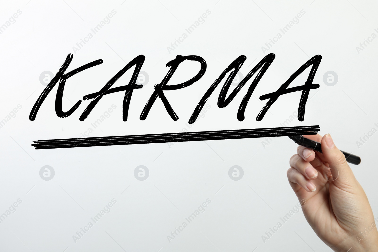 Image of Woman writing word KARMA on glass against white background, closeup