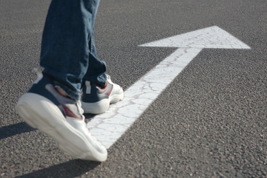 Photo of Man going along road with arrow marking, closeup