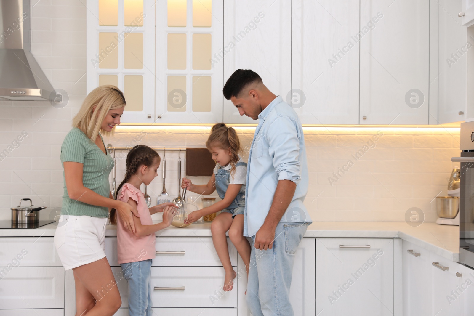 Photo of Happy family cooking together in modern kitchen