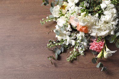 Photo of Bouquet of beautiful flowers on wooden table. Space for text