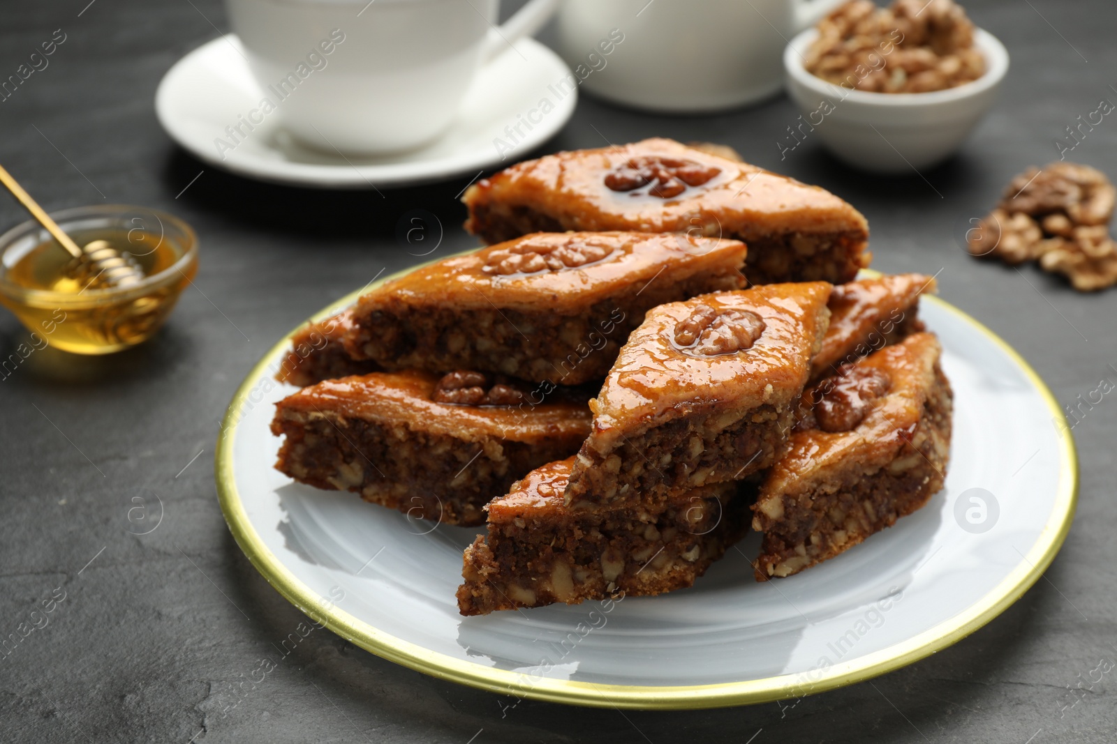 Photo of Delicious sweet baklava with walnuts on black table, closeup