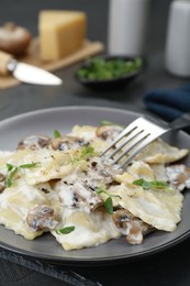 Photo of Delicious ravioli with tasty sauce and mushrooms served on table, closeup
