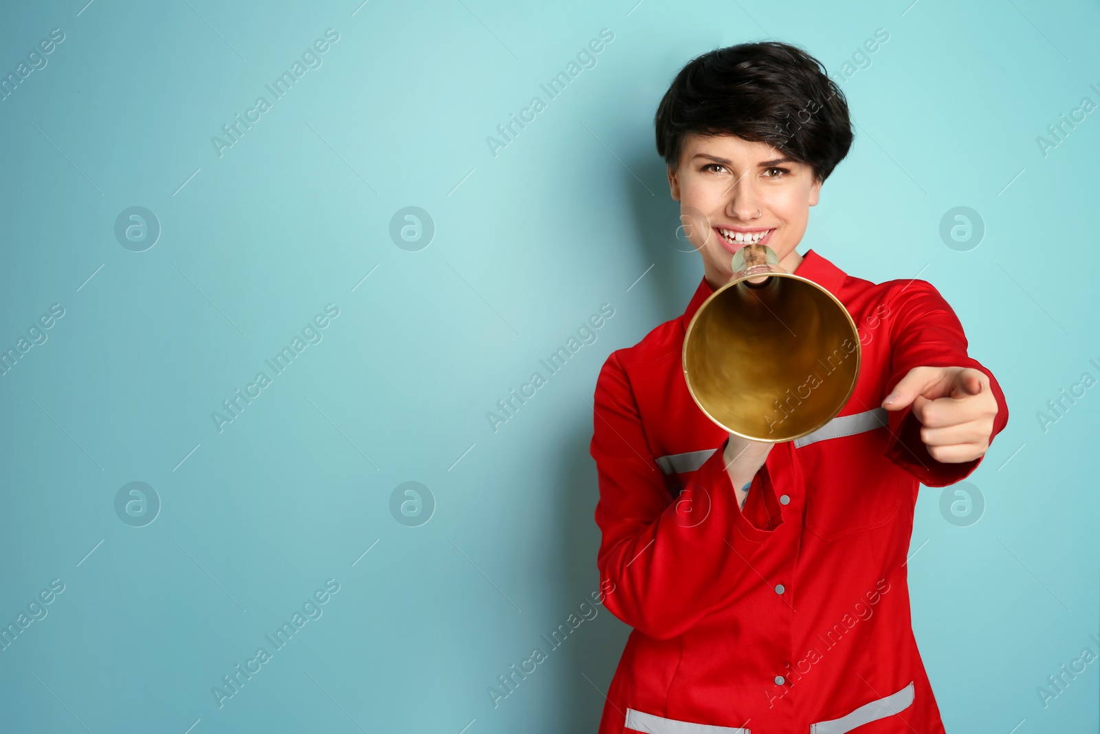 Photo of Young female doctor with megaphone on color background
