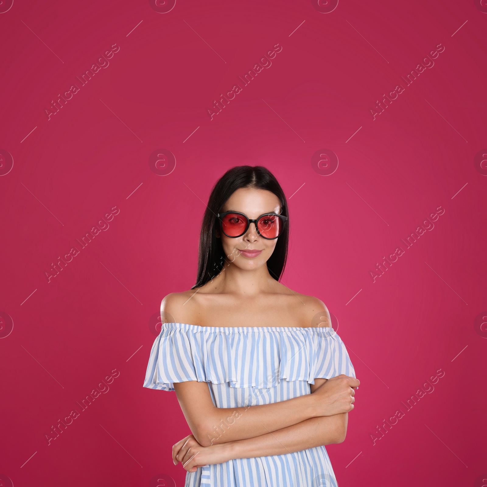 Photo of Beautiful woman wearing sunglasses on pink background