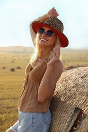 Photo of Happy hippie woman near hay bale in field