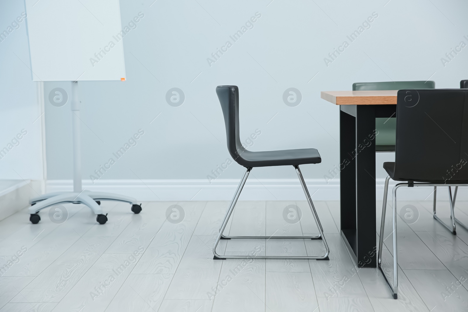 Photo of Conference room interior with wooden table and flipchart