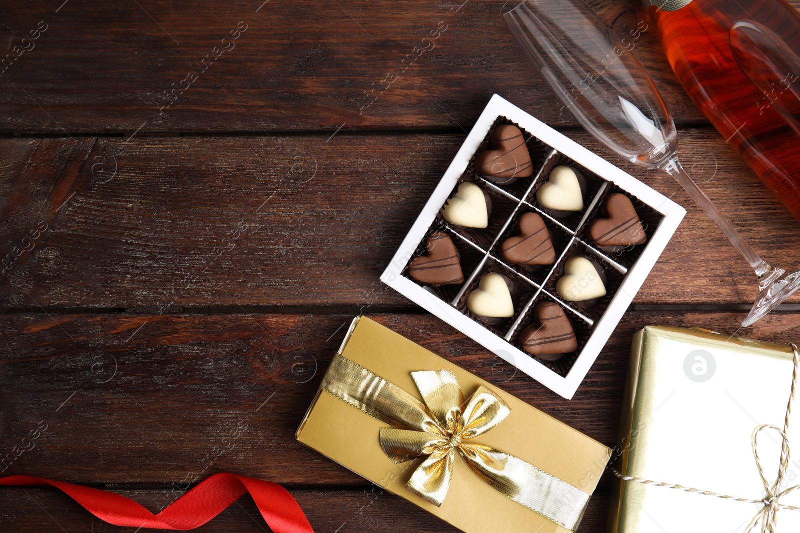 Photo of Flat lay composition with heart shaped chocolate candies on wooden table, space for text. Happy Valentine's day