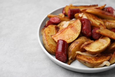 Photo of Delicious baked potato with thin dry smoked sausages and onion on gray table, closeup. Space for text