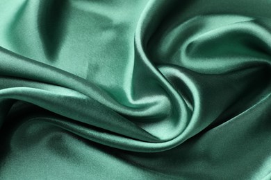 Photo of Crumpled green silk fabric as background, closeup