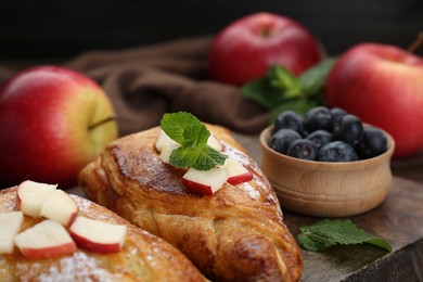 Photo of Fresh tasty puff pastry with blueberries, apples and mint served on table, closeup