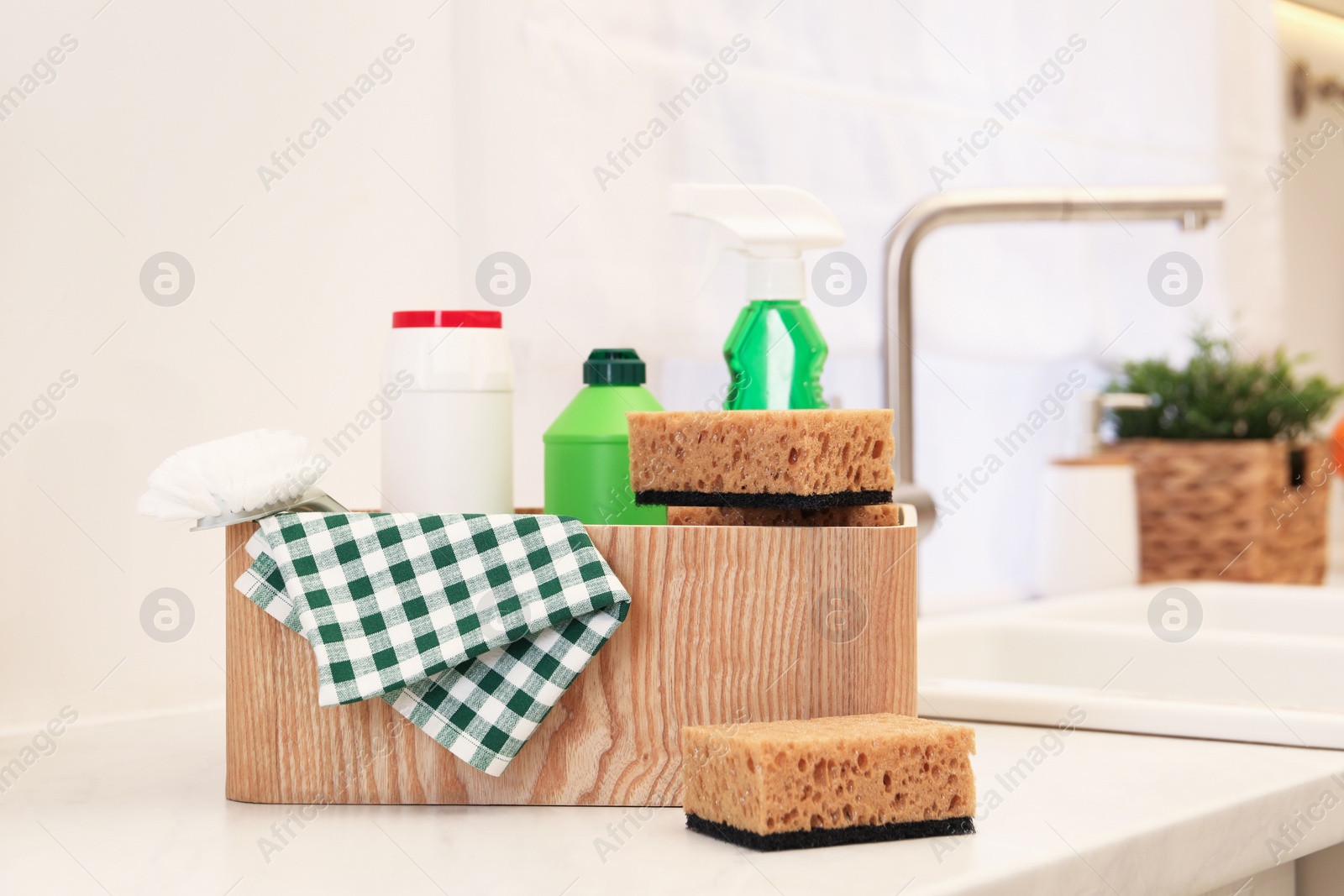 Photo of Different cleaning supplies on counter in kitchen