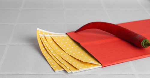 Photo of Pepper plasters and chili on white tiled table, closeup. Space for text