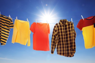 Different clothes drying on washing line against blue sky